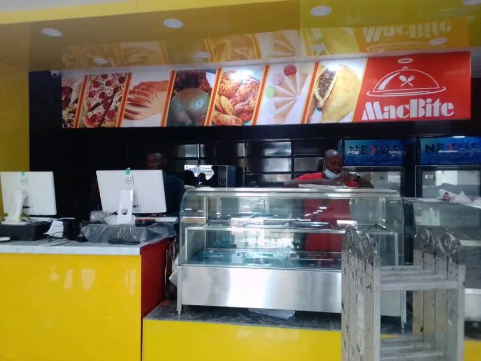 The MacBite service counter in Ibadan, with the pastry cabinet and the branded overhead sign